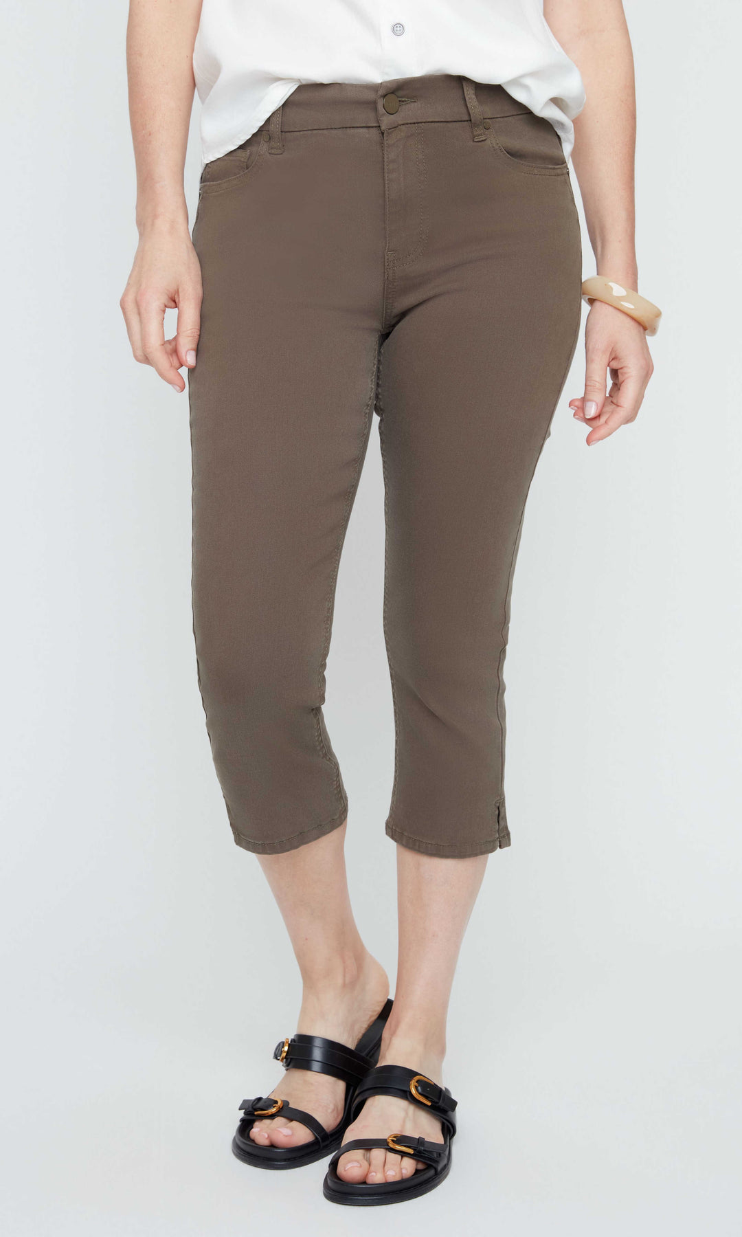 Person wearing brown capri pants on a white background