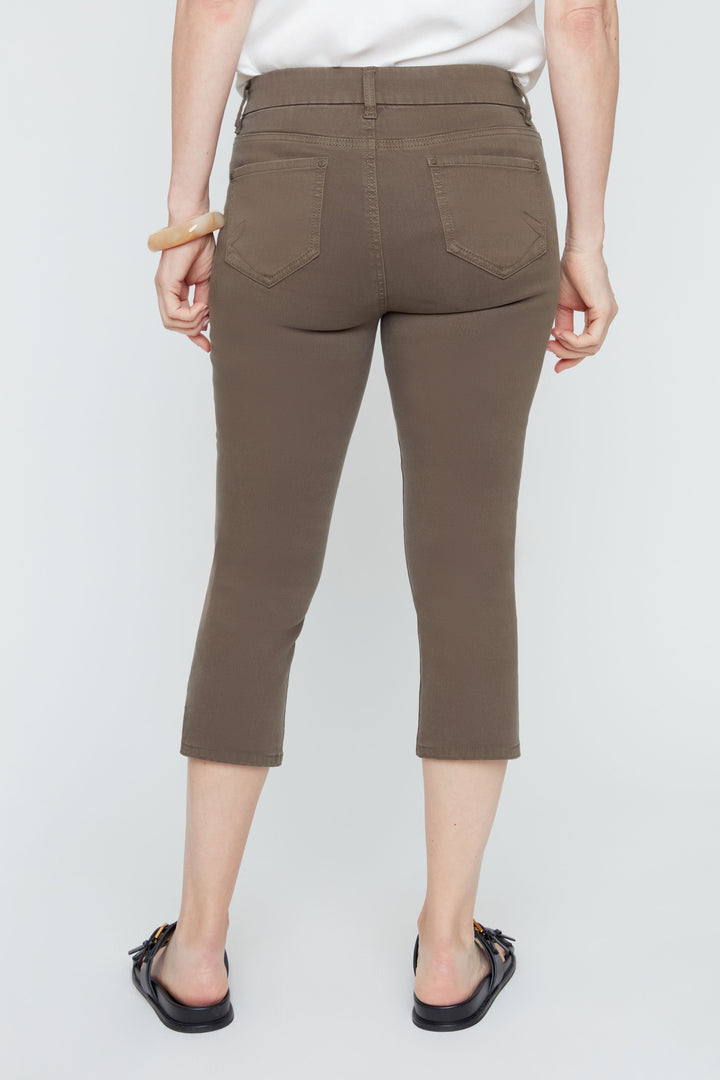 Person wearing brown capri pants on a white background