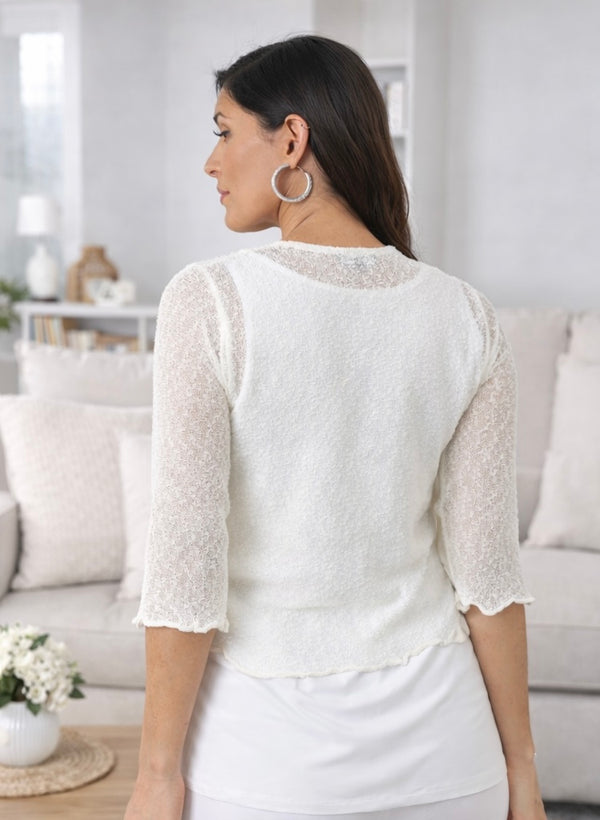 Woman wearing a white lace top in a living room setting