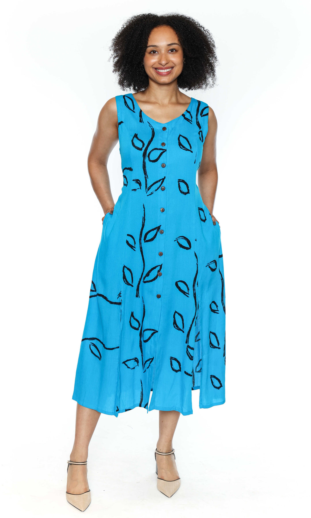 Woman wearing a blue dress with black leaf patterns on a white background