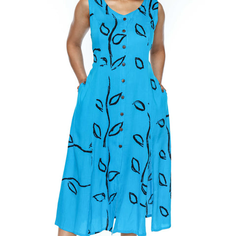 Woman wearing a blue dress with black leaf patterns on a white background