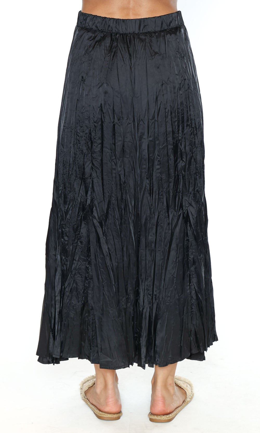 Black pleated skirt worn by a person on a white background