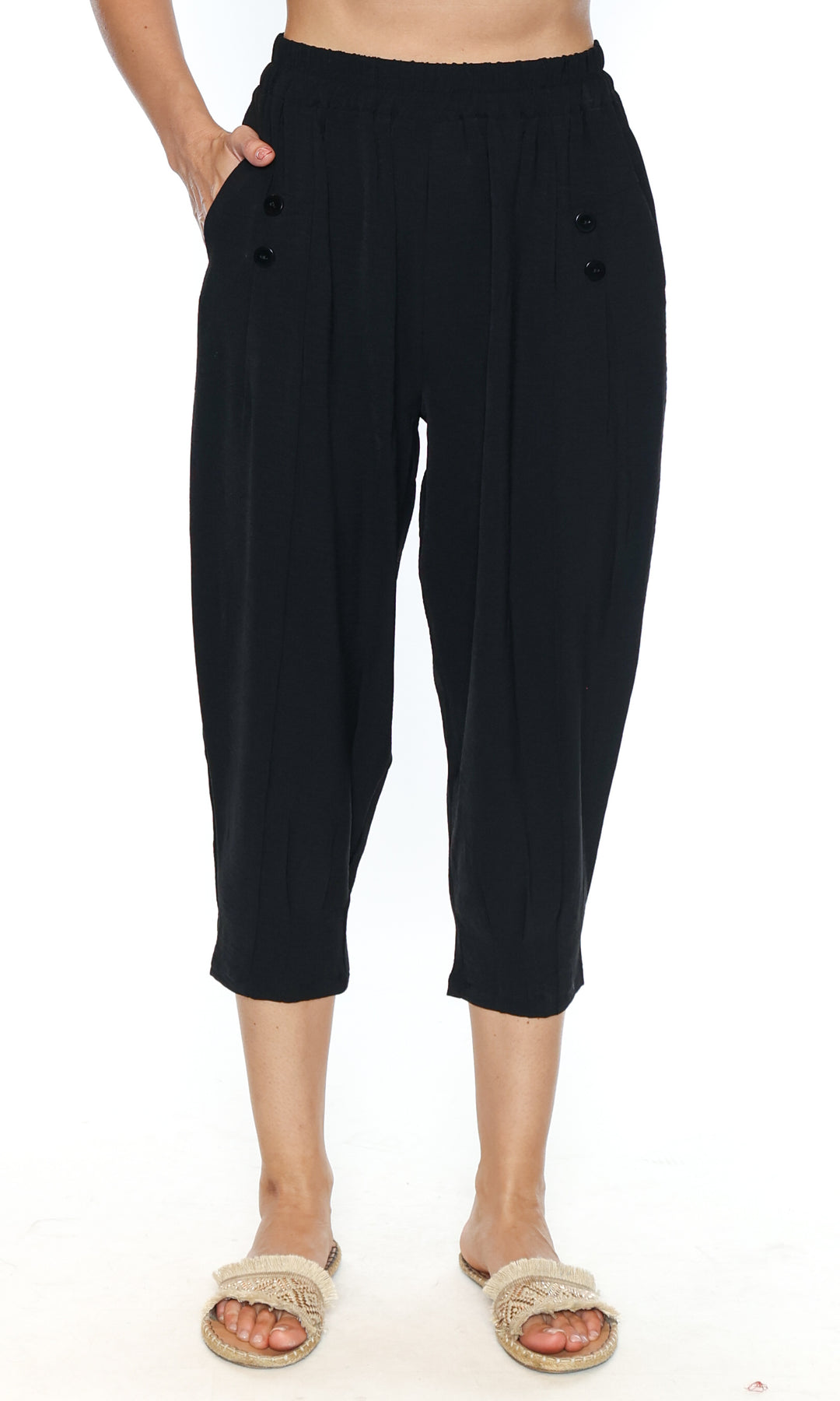 Black capri pants worn by a person on a white background