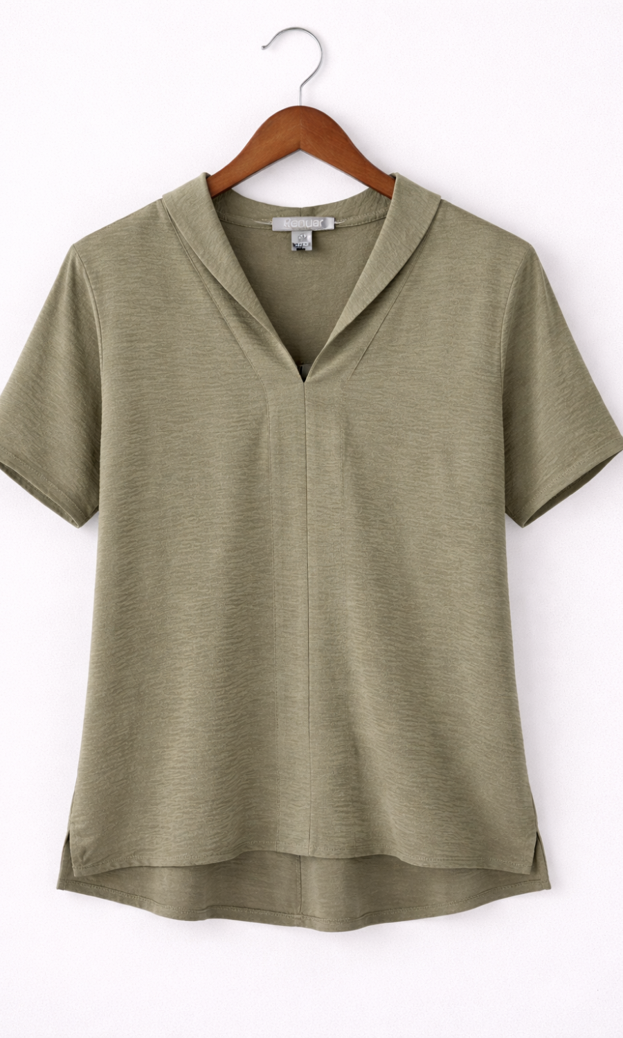 Green blouse on a wooden hanger against a white background
