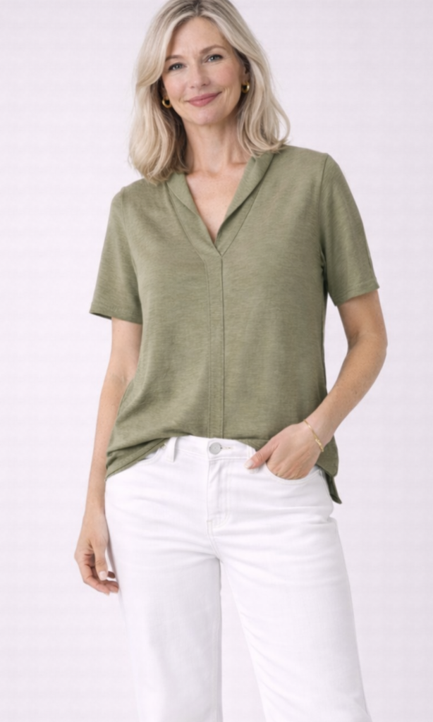 Woman wearing a green blouse and white pants on a white background