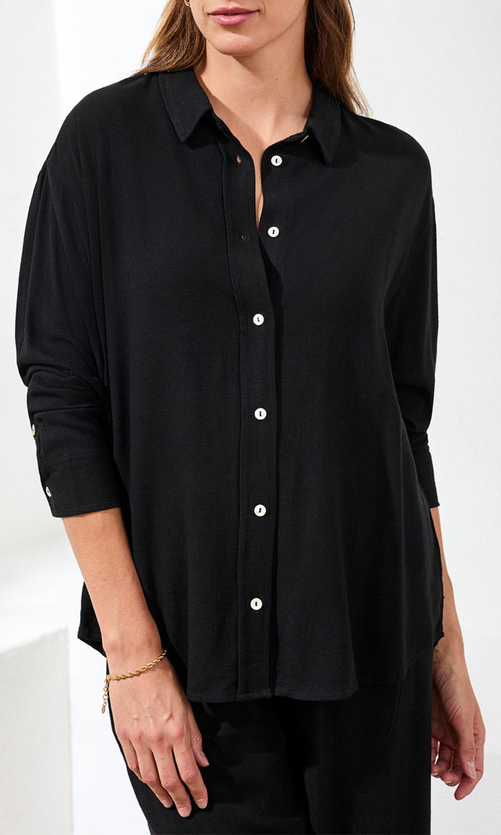 Woman wearing a black button-up shirt on a white background