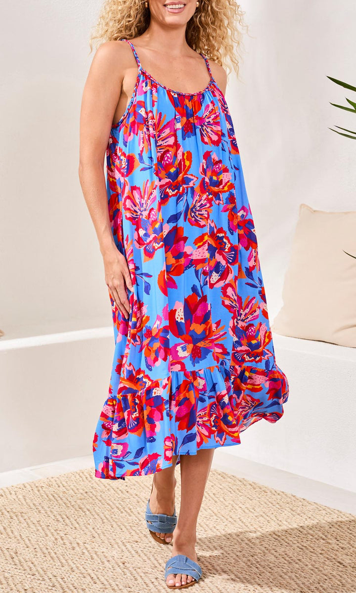 Woman wearing a colorful floral dress on a neutral background