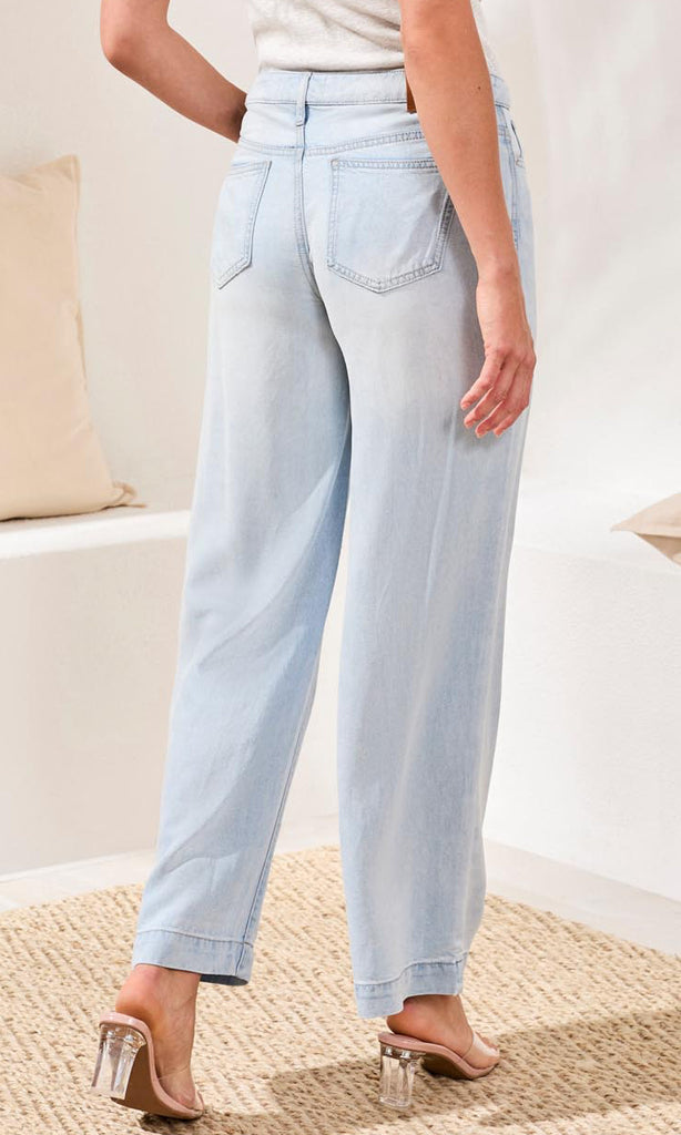Light blue jeans worn by a person on a neutral background