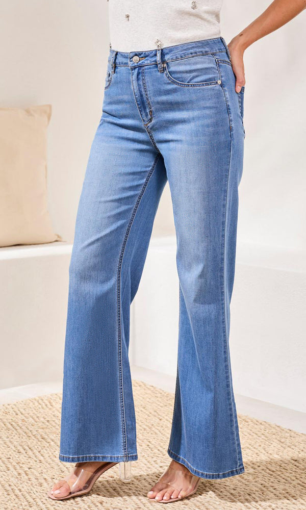 Person wearing blue jeans on a neutral background