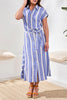 Woman wearing a blue and white striped dress in a minimal indoor setting.