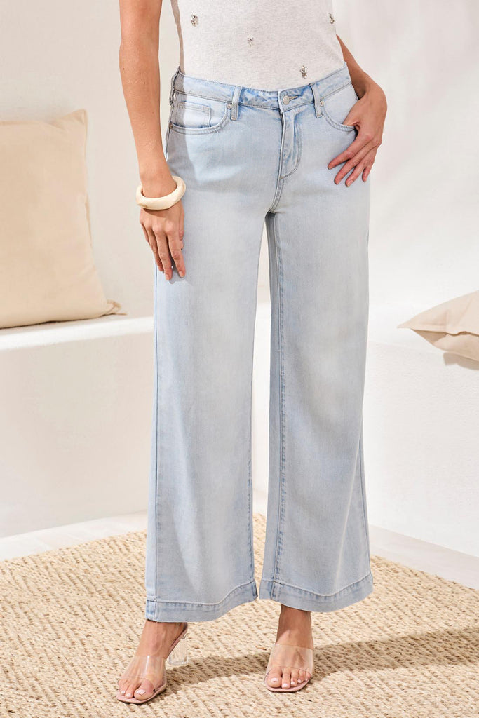 Light blue jeans worn by a person in a minimal indoor setting