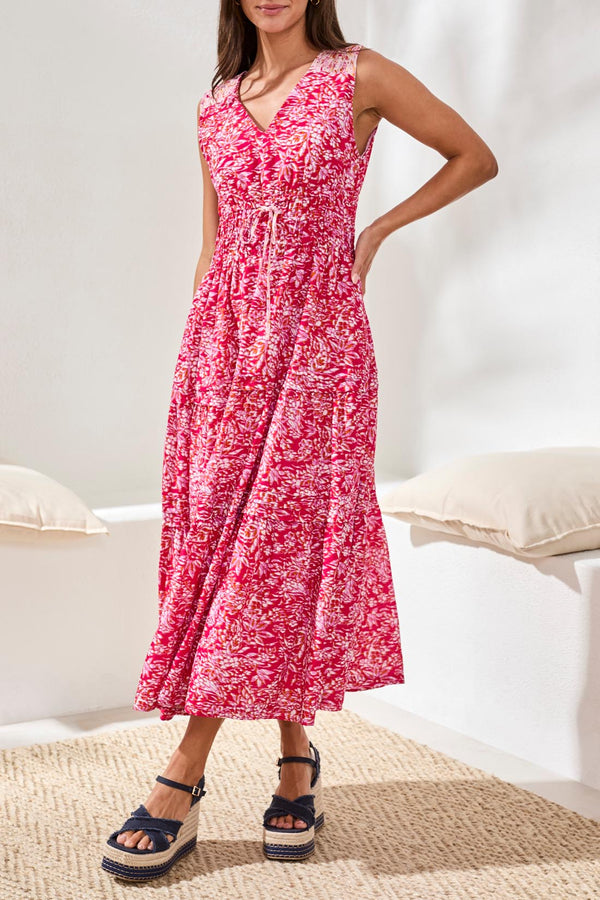 Woman wearing a pink floral dress in a bedroom setting