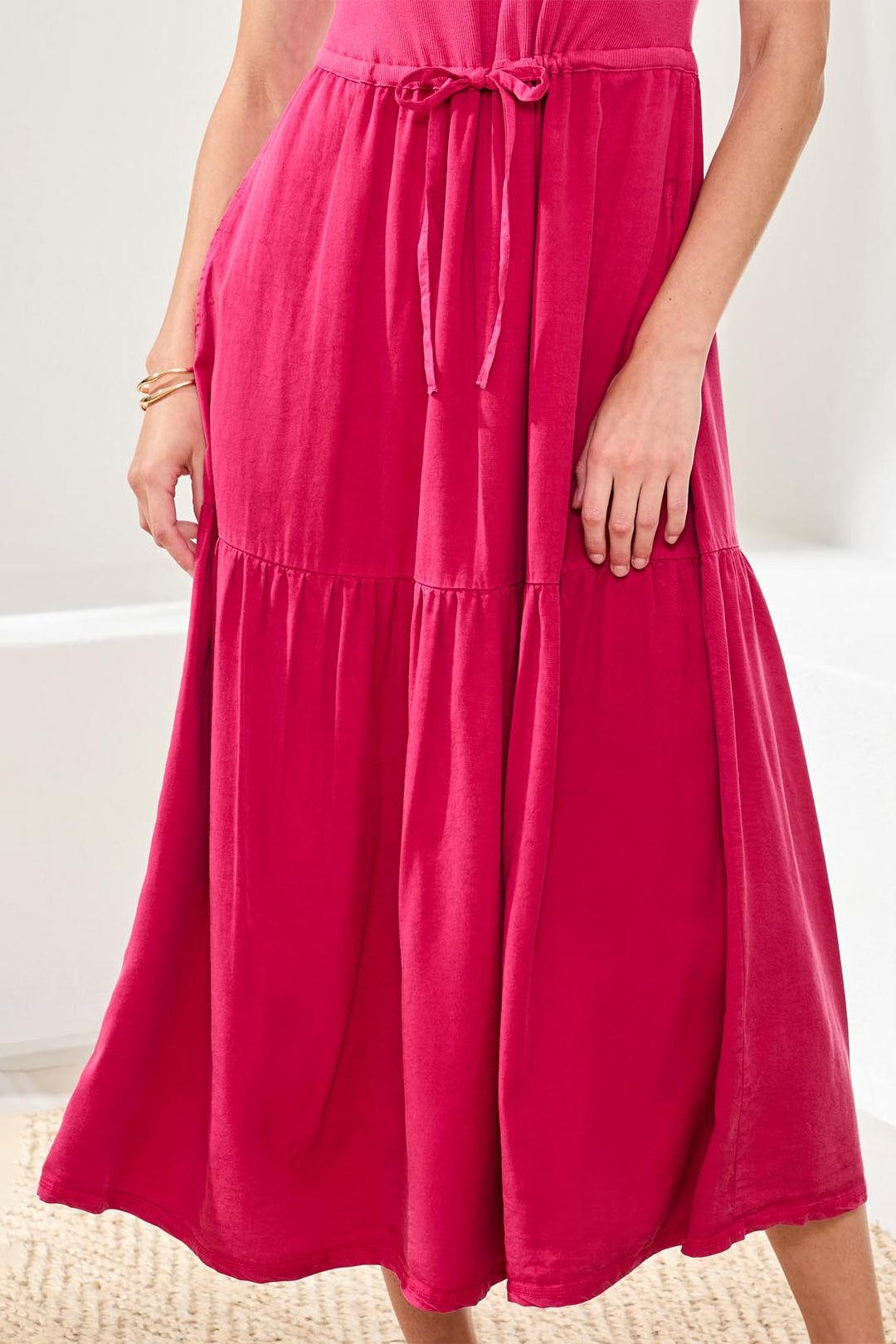 Person wearing a bright pink dress on a white background
