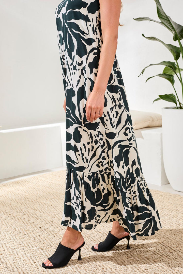 Person wearing a patterned dress with black high-heeled shoes in a home setting.