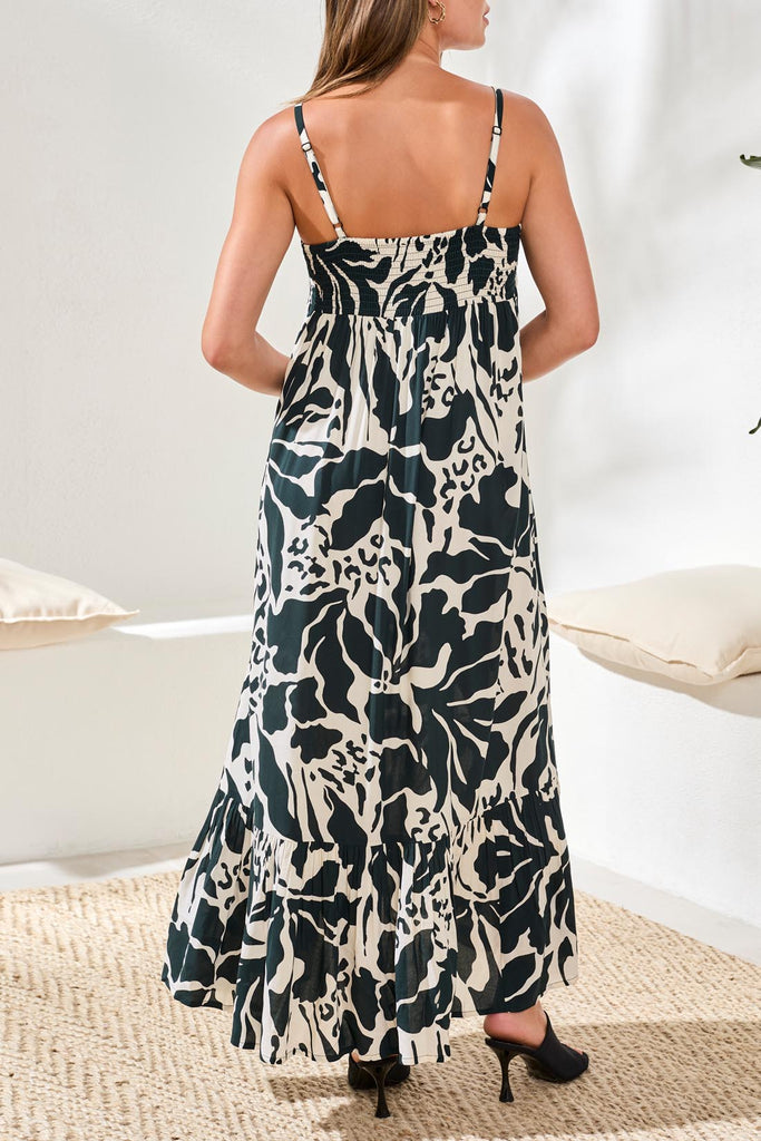 Woman wearing a black and white patterned dress in a minimal indoor setting