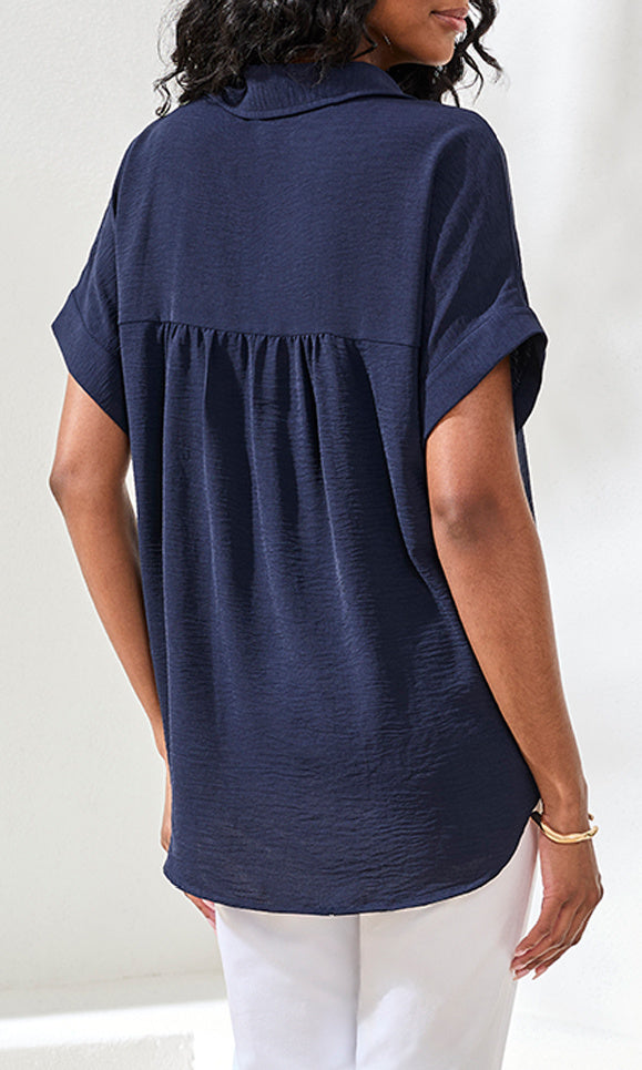 Navy blue short-sleeve blouse worn by a person on a white background